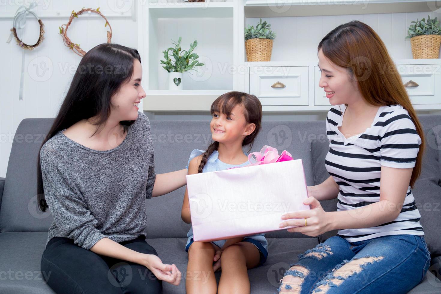 gelukkige familie, moeder en dochter geven geschenkdoos met dochter. foto