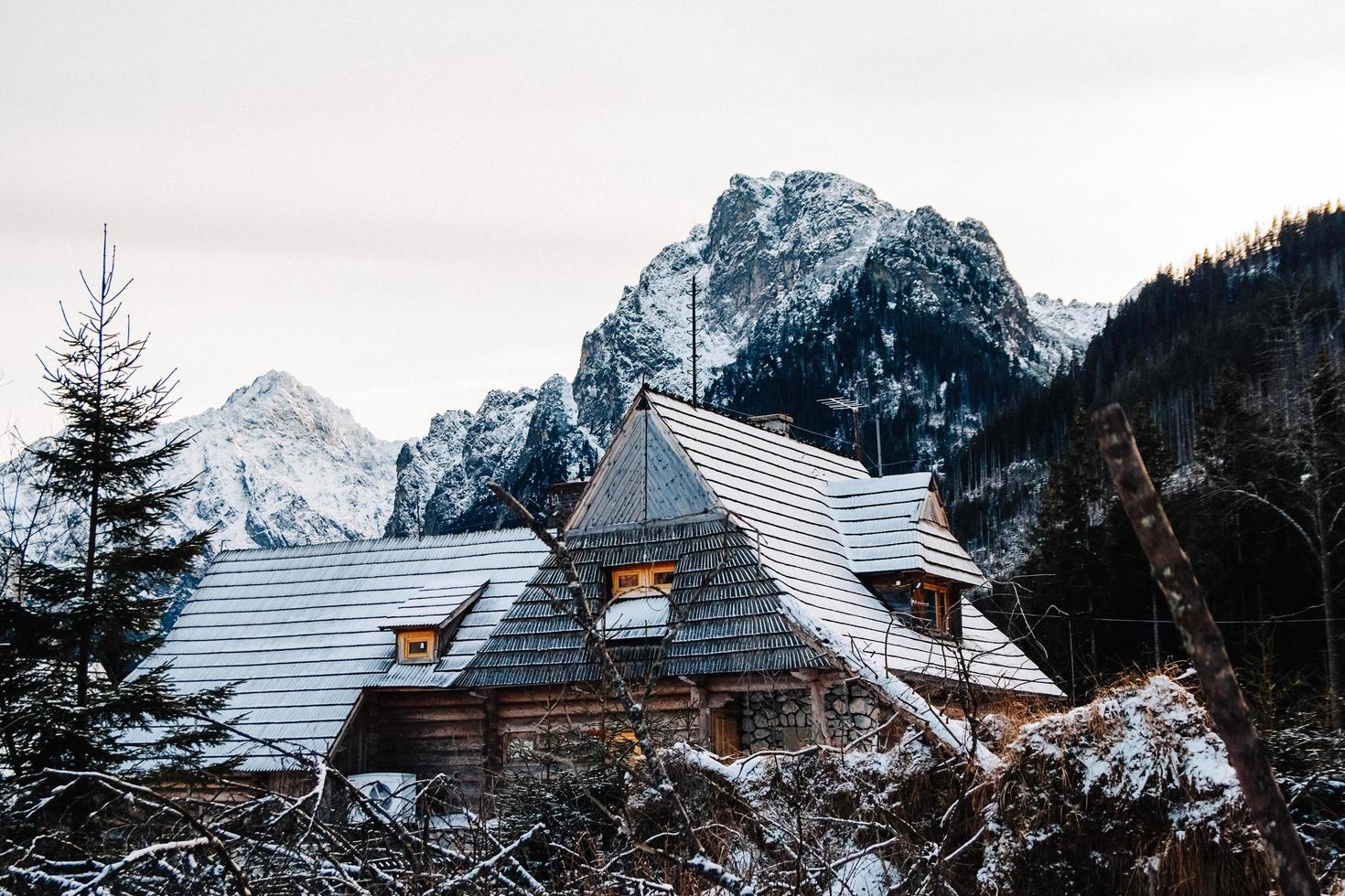 houten huis in de bergen bedekt met verse sneeuw in de winterbergen foto