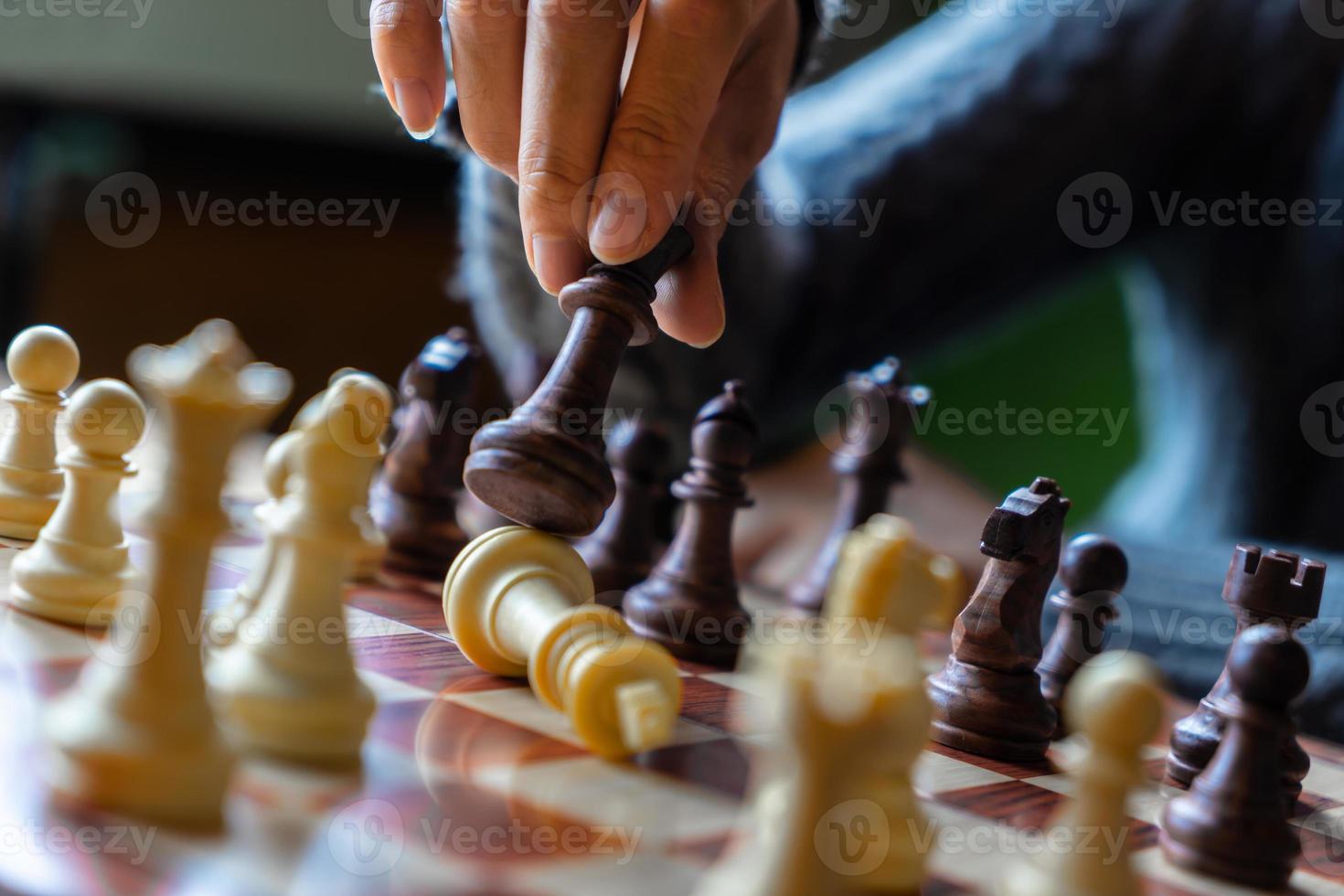 hand van zakenvrouw die schaak speelt voor spel in competitiesucces foto