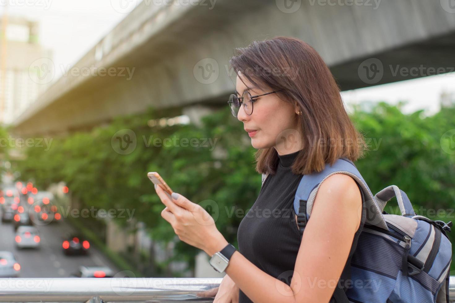 vrouwelijke reiziger gebruikt smartphones om reiskaarten in bangkok te vinden. foto