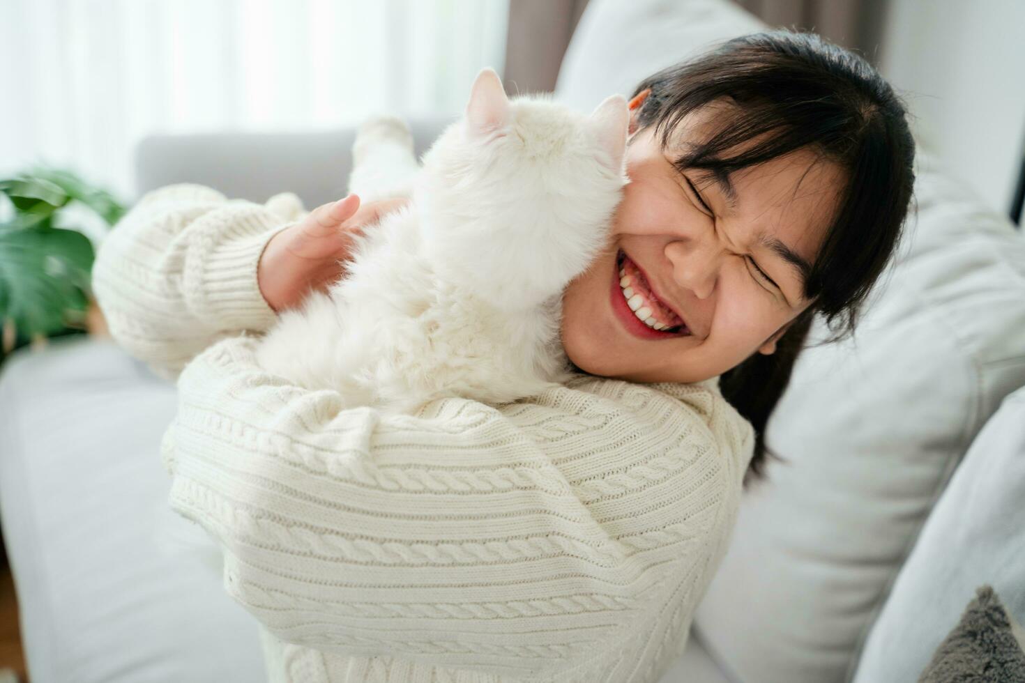 gelukkig vrouw spelen met kat in knus leven kamer Bij huis. foto