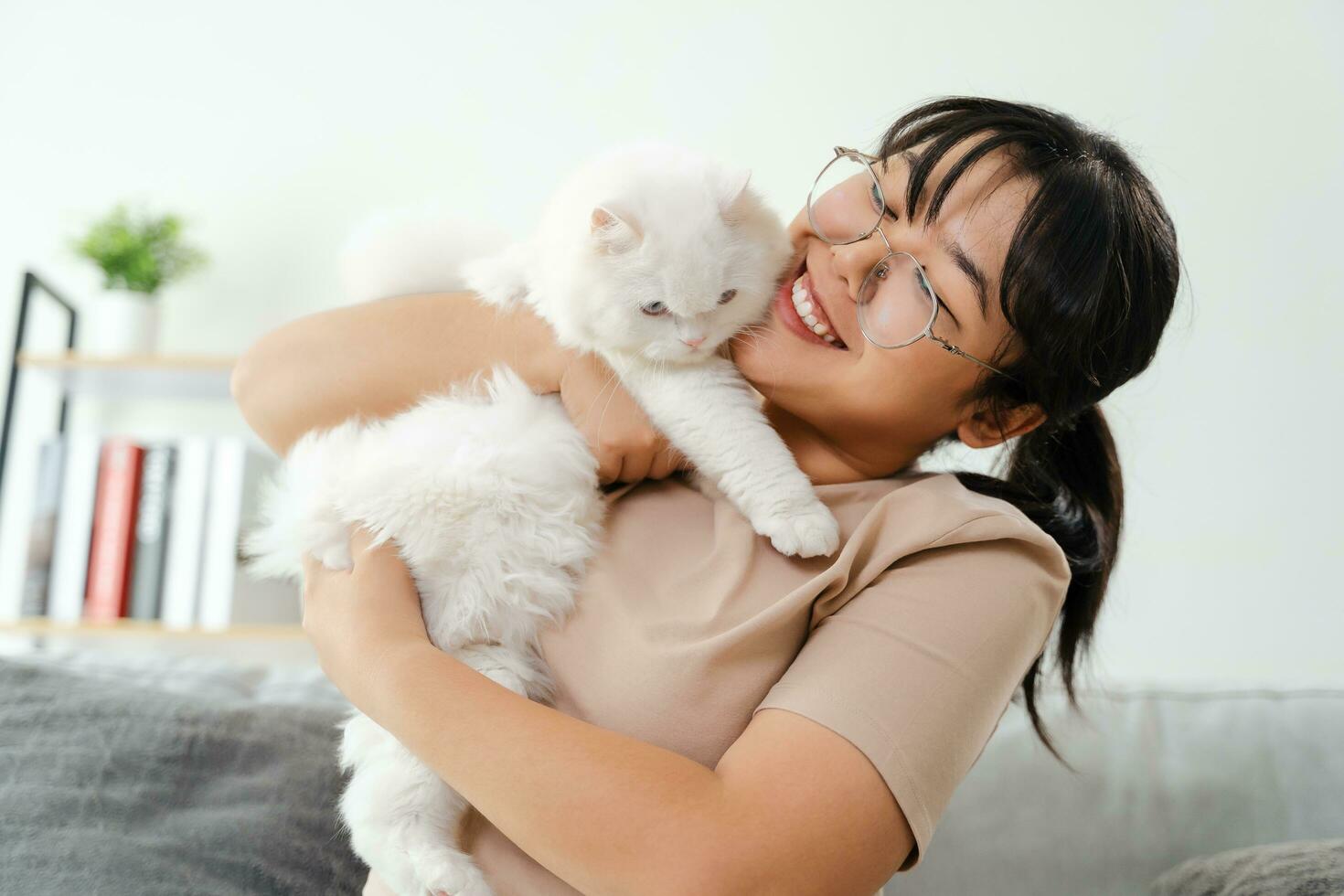 gelukkig vrouw spelen met kat in knus leven kamer Bij huis. foto