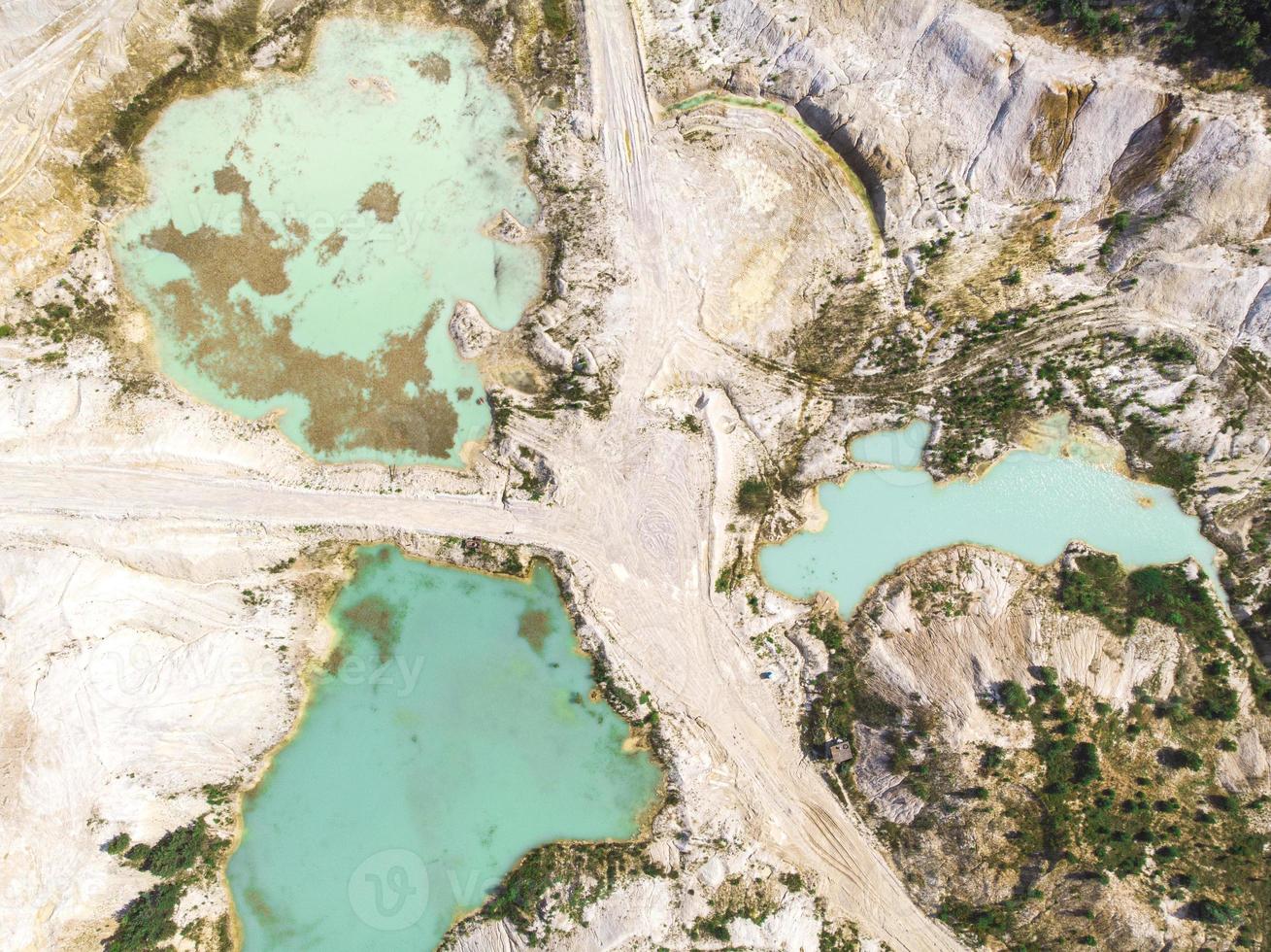 drone-uitzicht op een ondergelopen kaoliengroeve, turquoise water en witte kust foto