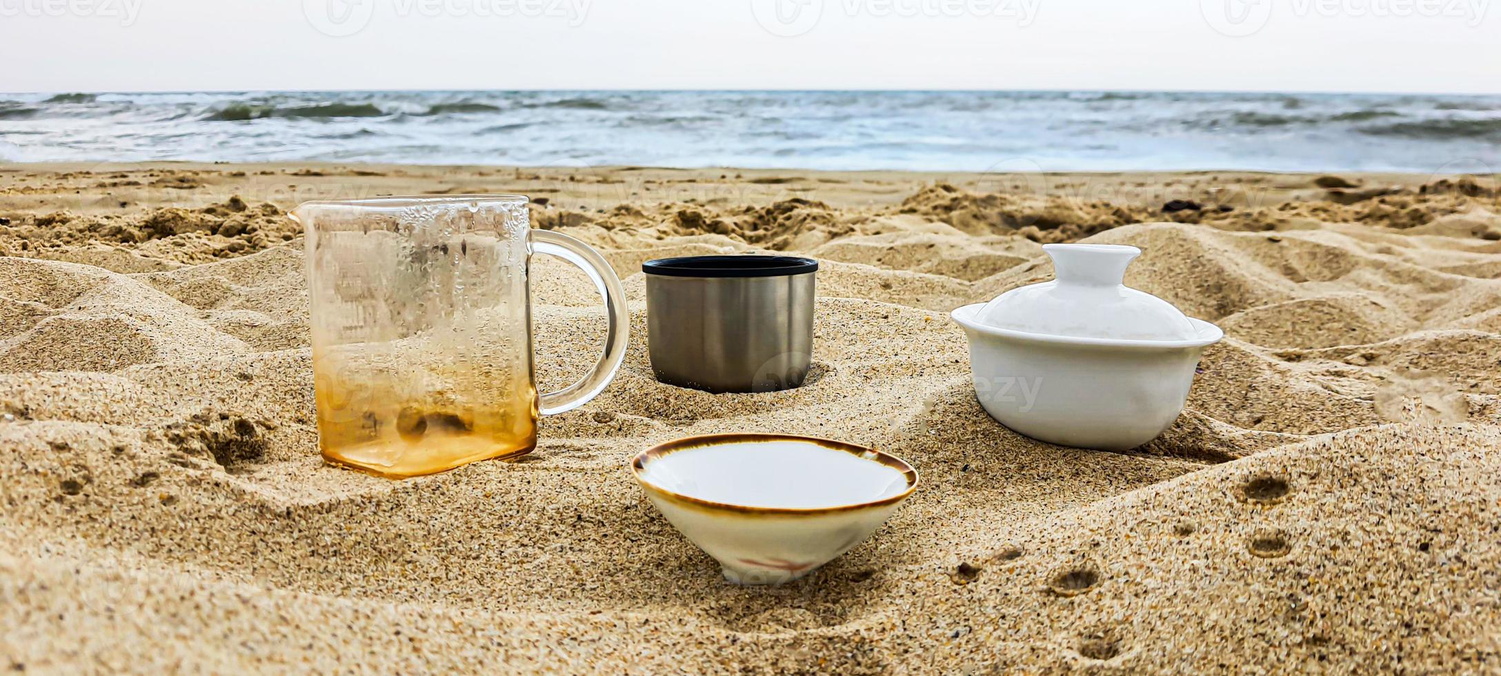 kust. gerechten met thee op het zand. zomervakantie. foto