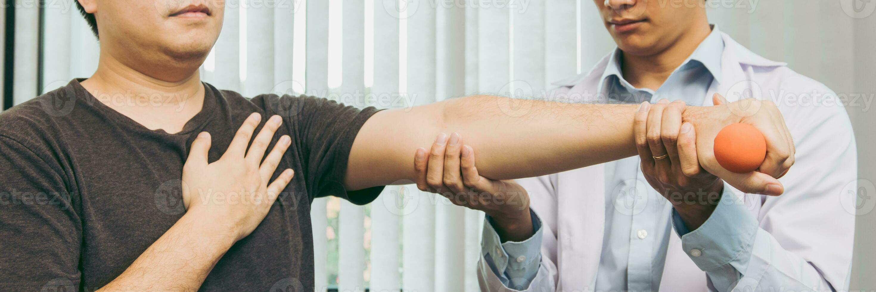 Aziatische jonge mannelijke fysiotherapeut die patiënt helpt met het opheffen van dumbbells-oefeningen in de kliniek. foto