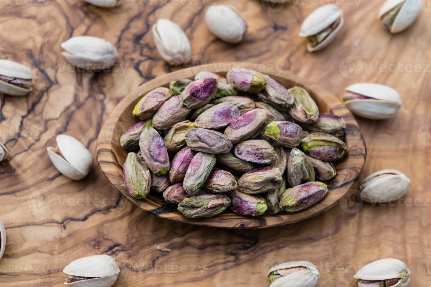 gezouten pistachenoten op olijfhout foto