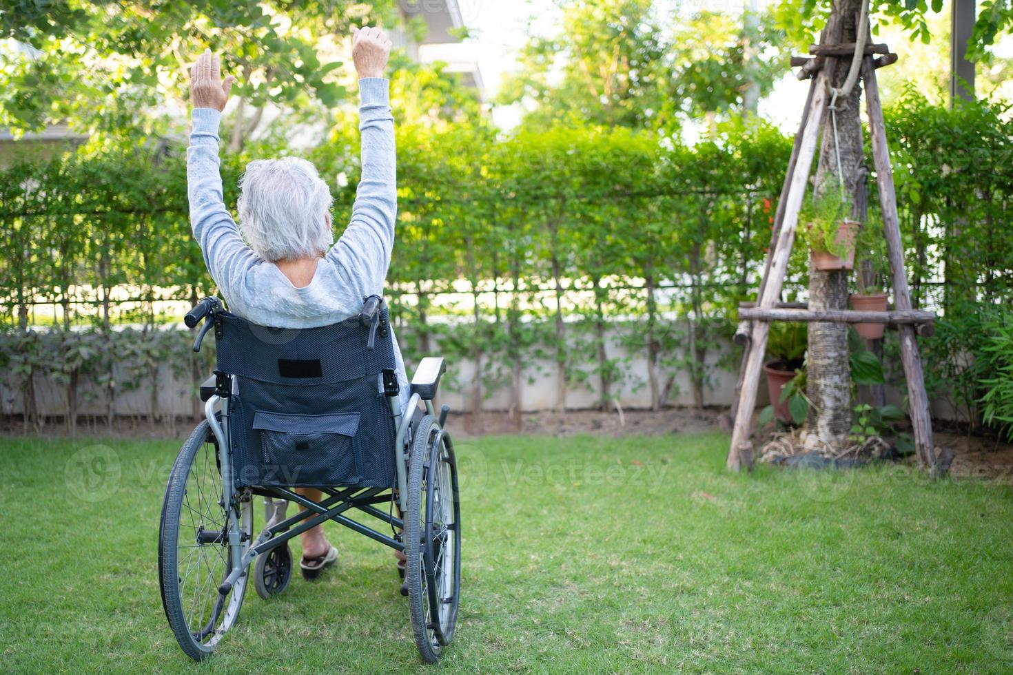 Aziatische senior vrouw patiënt oefening op rolstoel foto