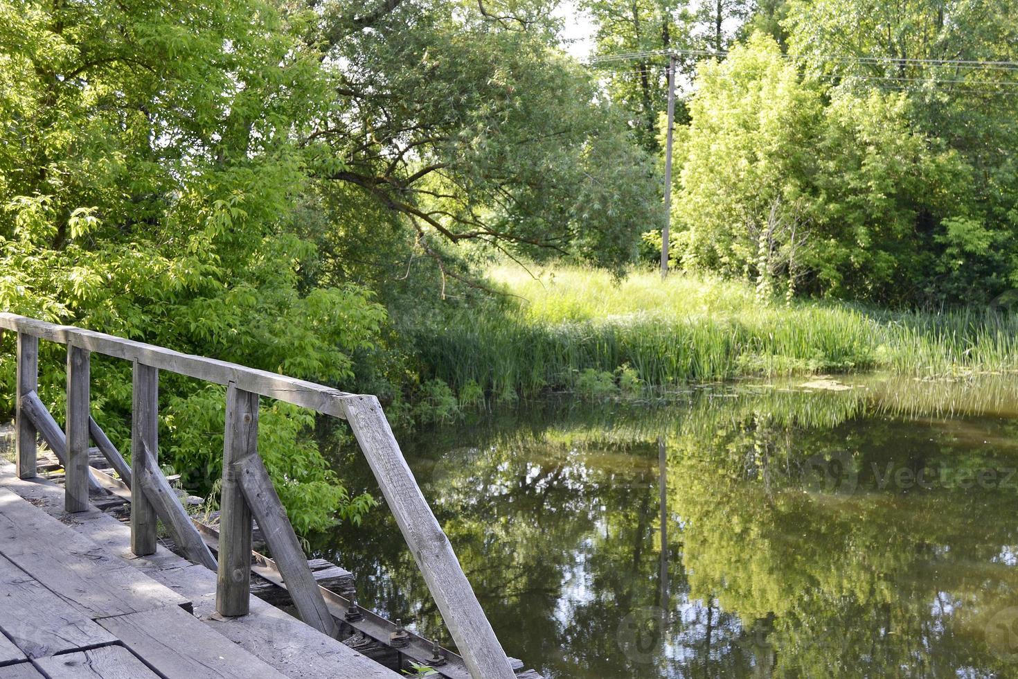 staande oude houten brug over rivier in gekleurde achtergrond foto