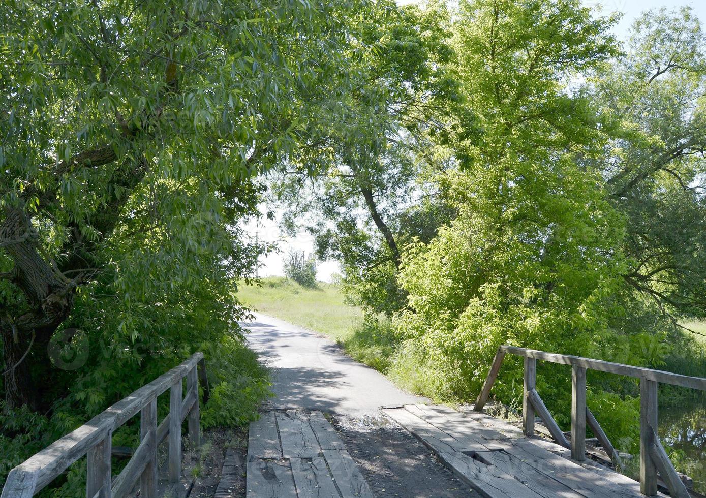 staande oude houten brug over rivier in gekleurde achtergrond foto