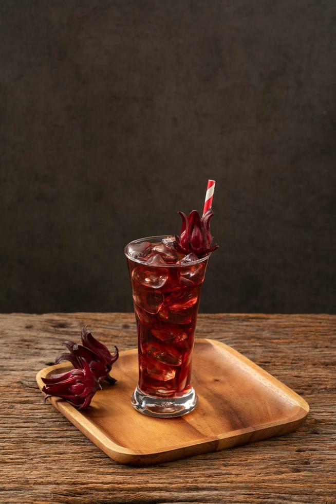 roselle helder glas met vers roselle fruit op houten tafel foto