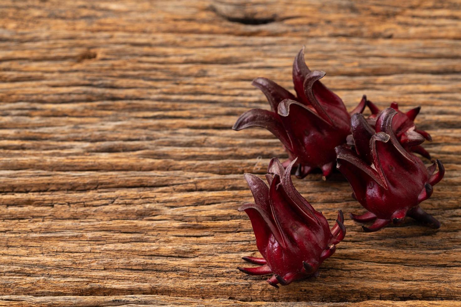 roselle helder glas met vers roselle fruit op houten tafel foto