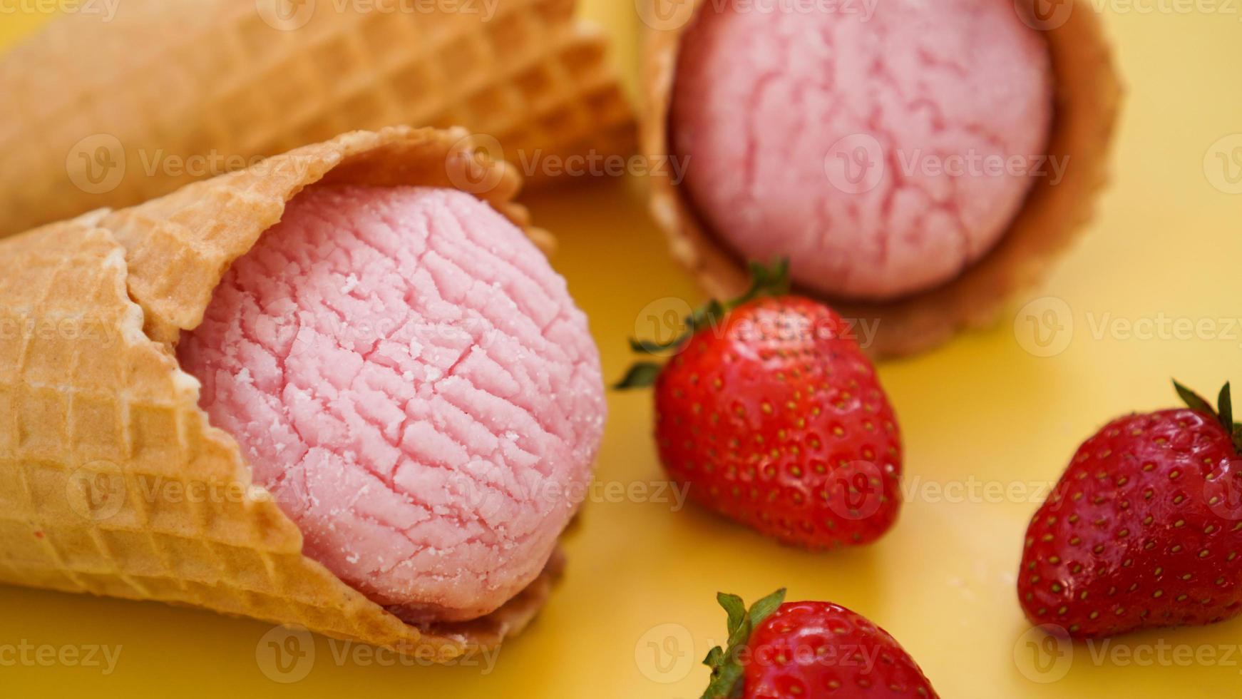 Aardbeienroomijs in een wafelkegel. Softijs foto