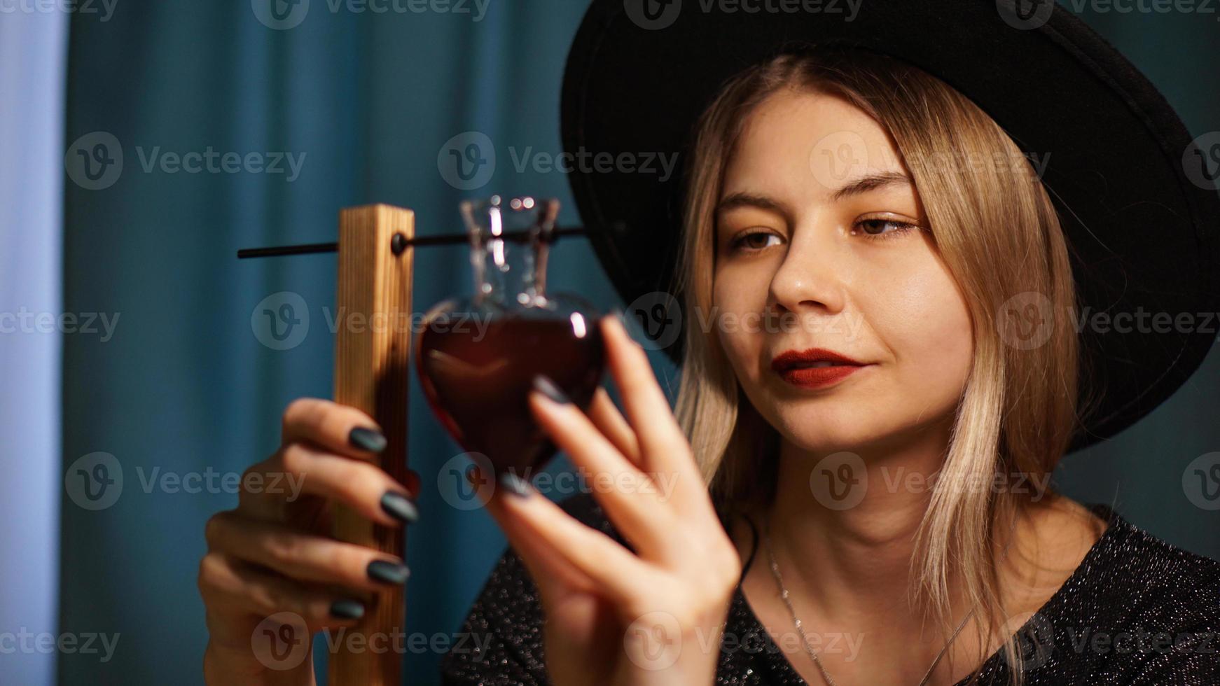 de vrouw heks bereidt een drankje. rode liefdesdrank foto