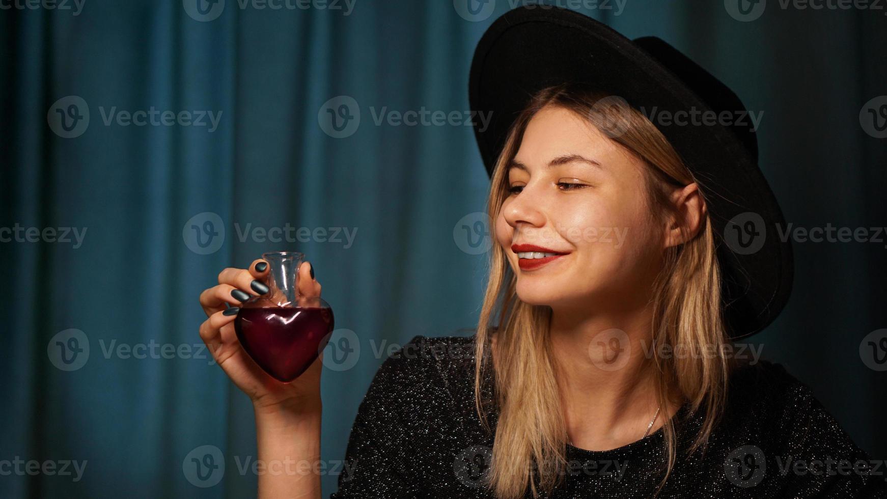 bijgesneden afbeelding van vrouw met hartvormige glazen pot liefdesdrank foto