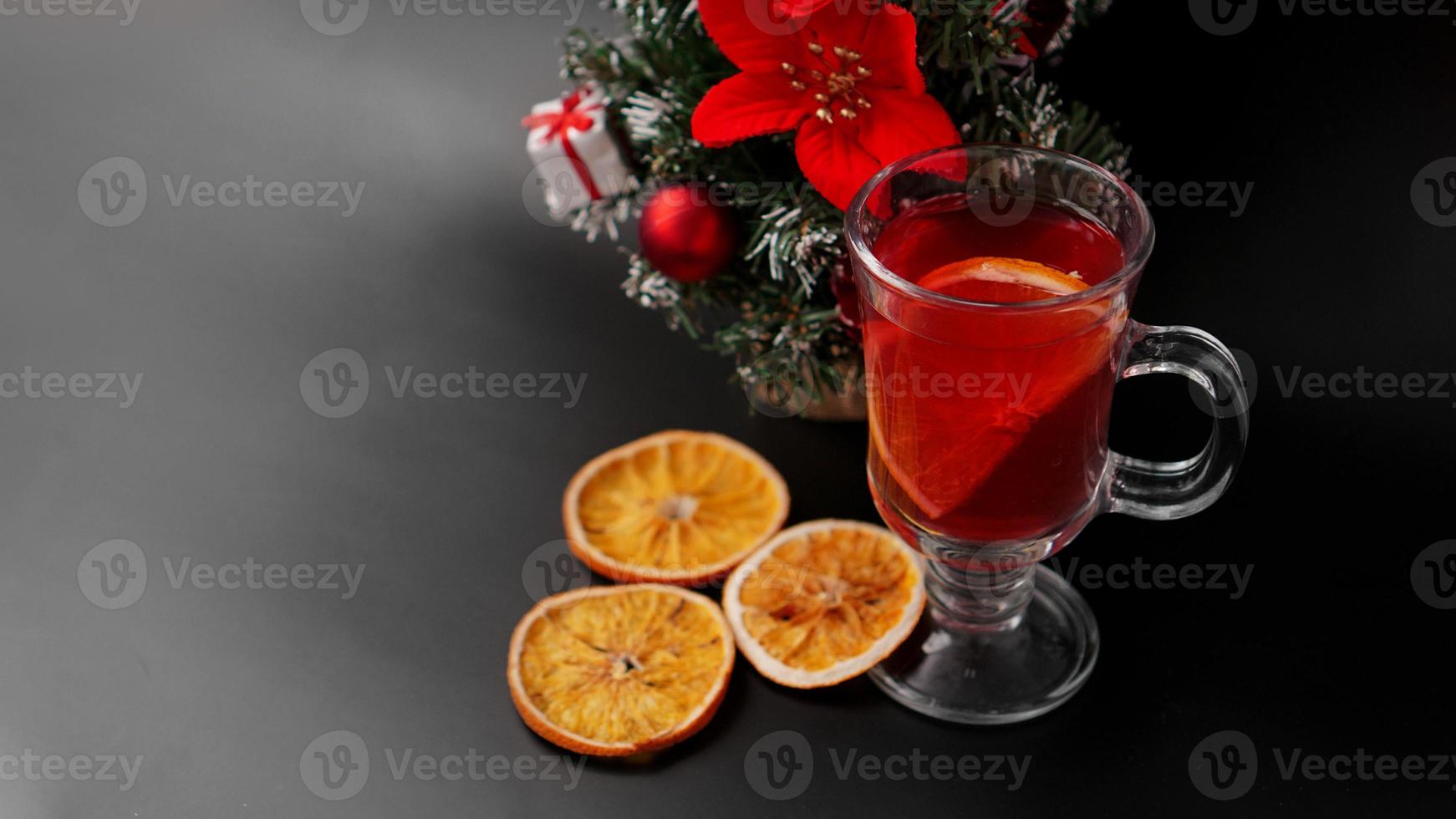 Glühwein in glas op zwarte tafel met nieuwjaarsdecoratie foto