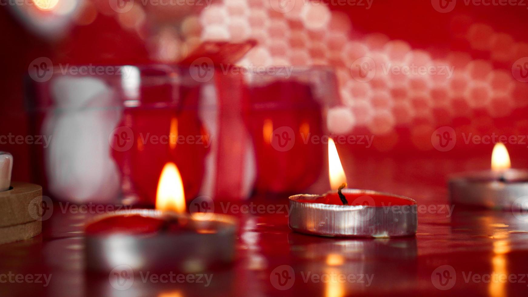 kaarsen voor Valentijnsdag, tafel met feestelijke rode achtergrond foto