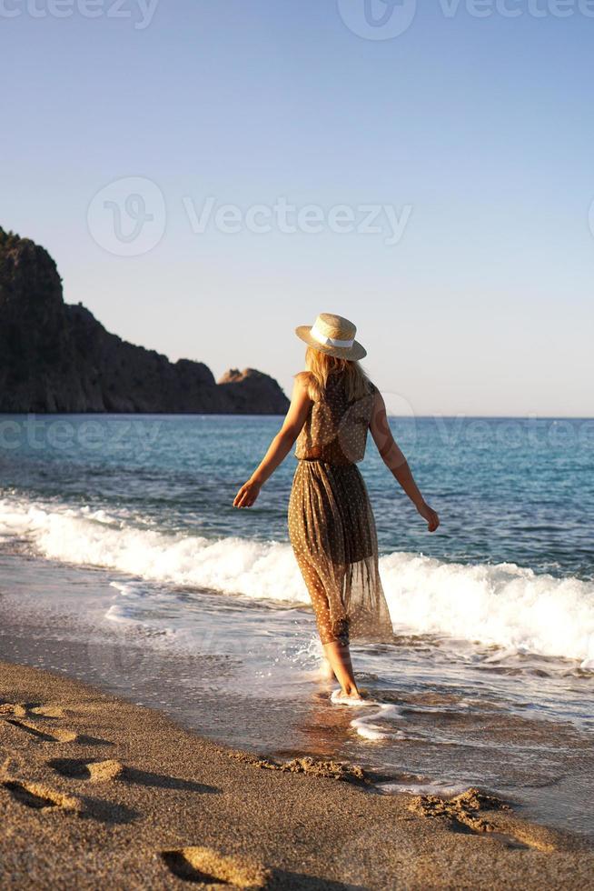 vrouw op het strand in een bruine jurk foto