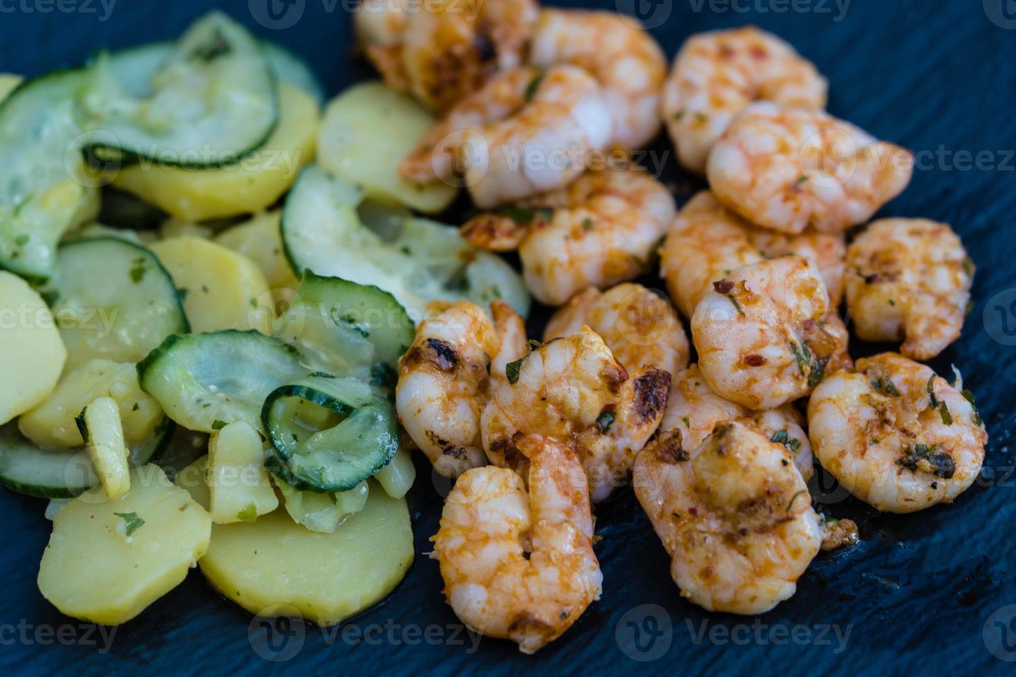 pittige witte tijgergarnalen van de grill met aardappel-komkommersalade foto