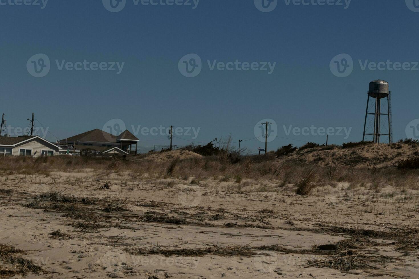 ik liefde de kijken van deze mooi strand tafereel.. de zee puin leggen verspreide in de omgeving van met de mooi zand allemaal in de omgeving van. de bruin zand duinen in de achtergrond met de water toren en klein dorp. foto