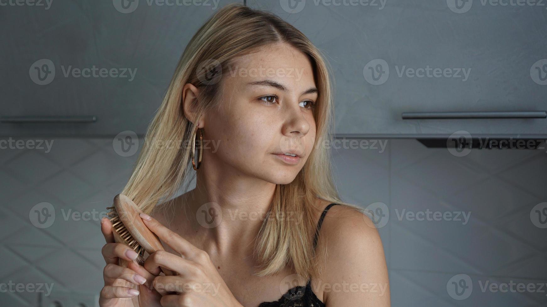 jonge mooie vrouw die haar haar rechtmaakt foto