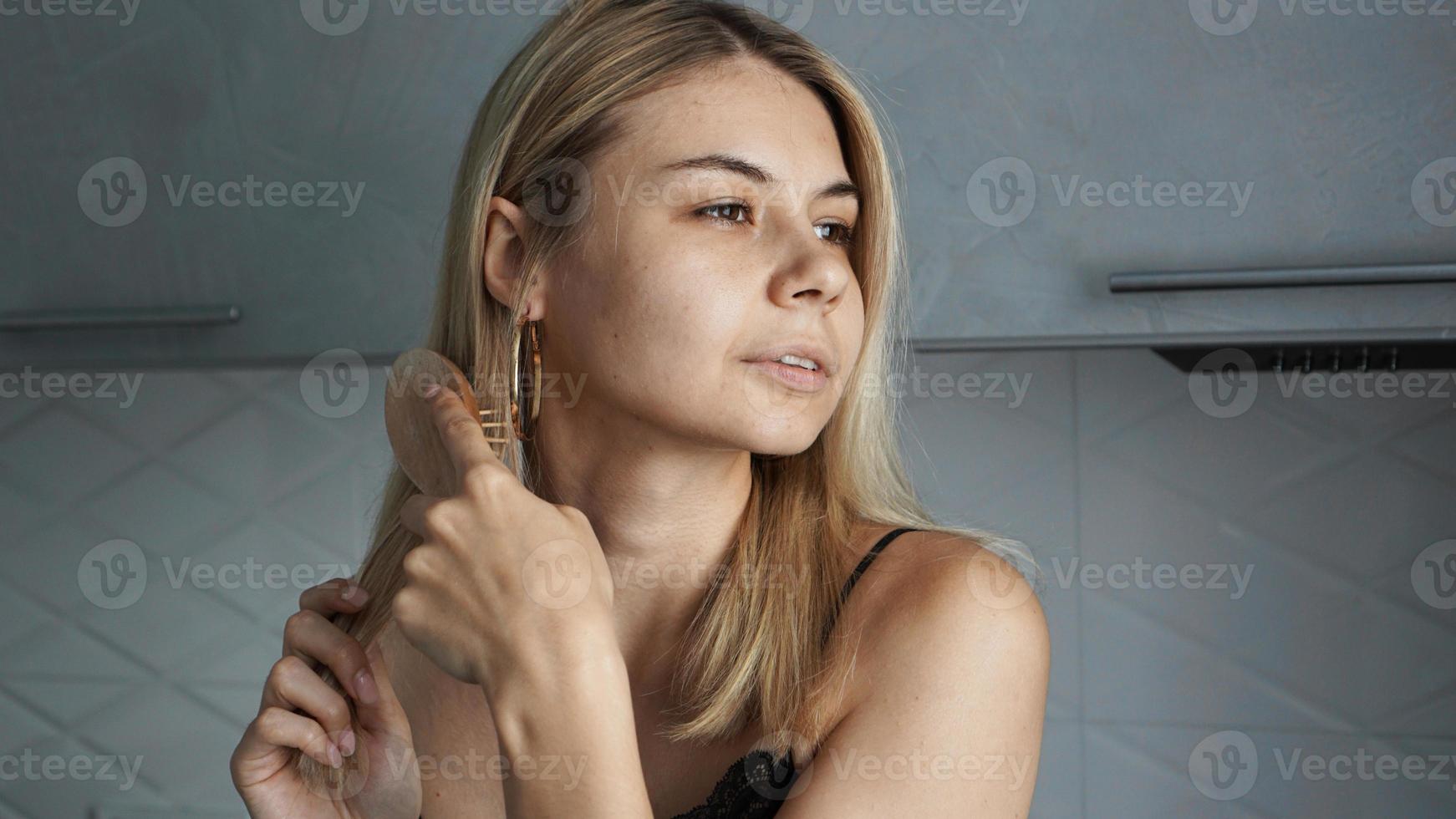 jonge mooie vrouw die haar haar rechtmaakt foto