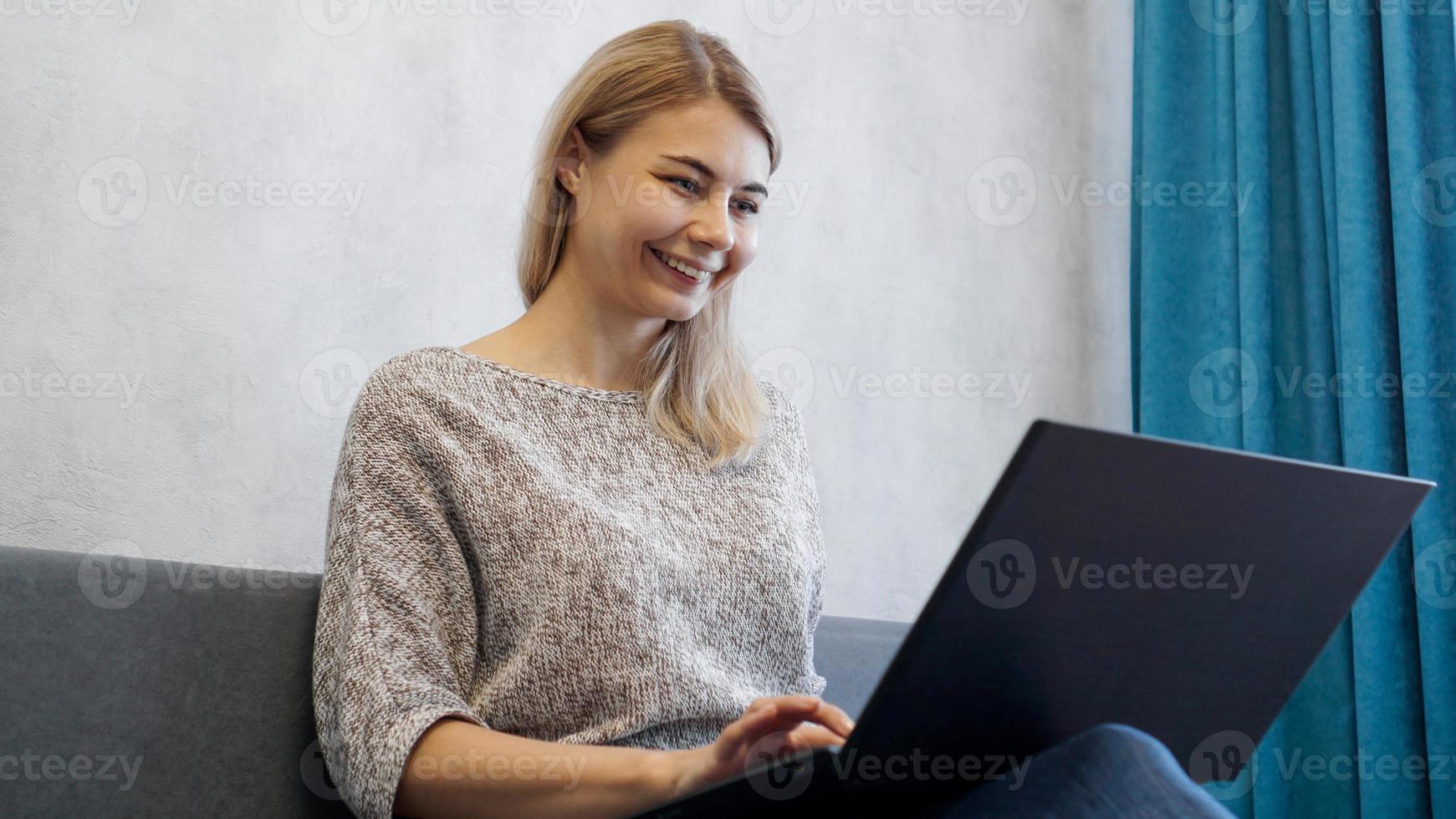 casual jonge vrouw die laptop in de woonkamer gebruikt foto