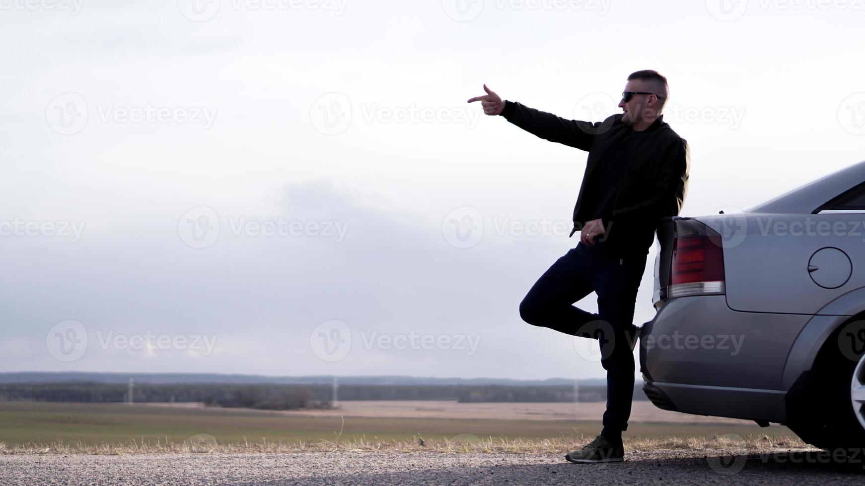 sde weergave van zakenman in bril zittend op auto kofferbak foto