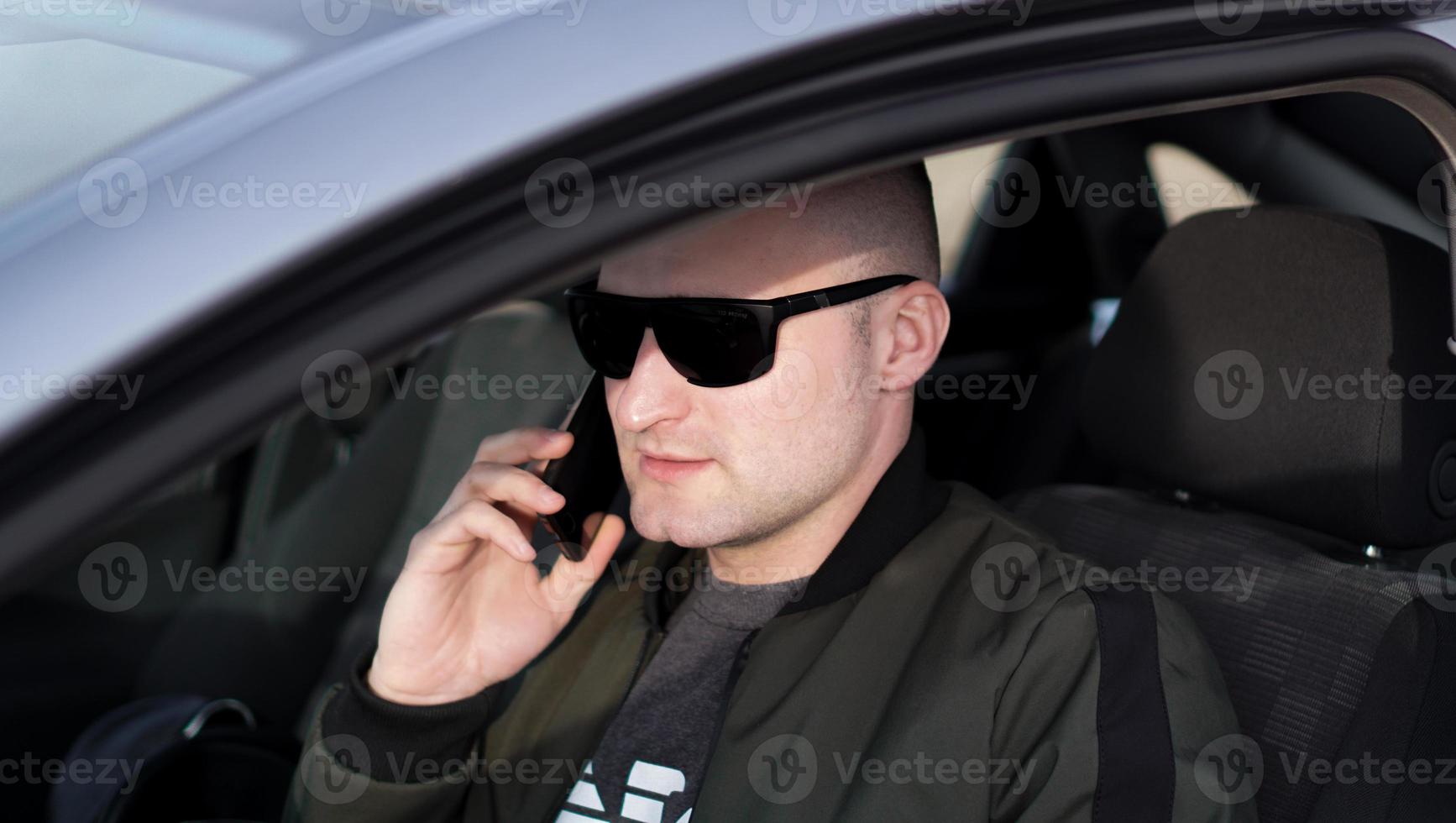 man praten op een mobiele telefoon tijdens het autorijden. foto