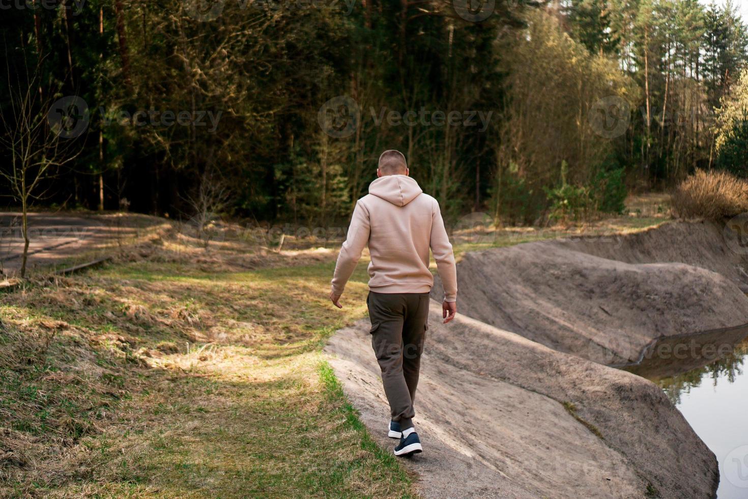 een man loopt door het bos naast een roeikanaal of bergrivier foto