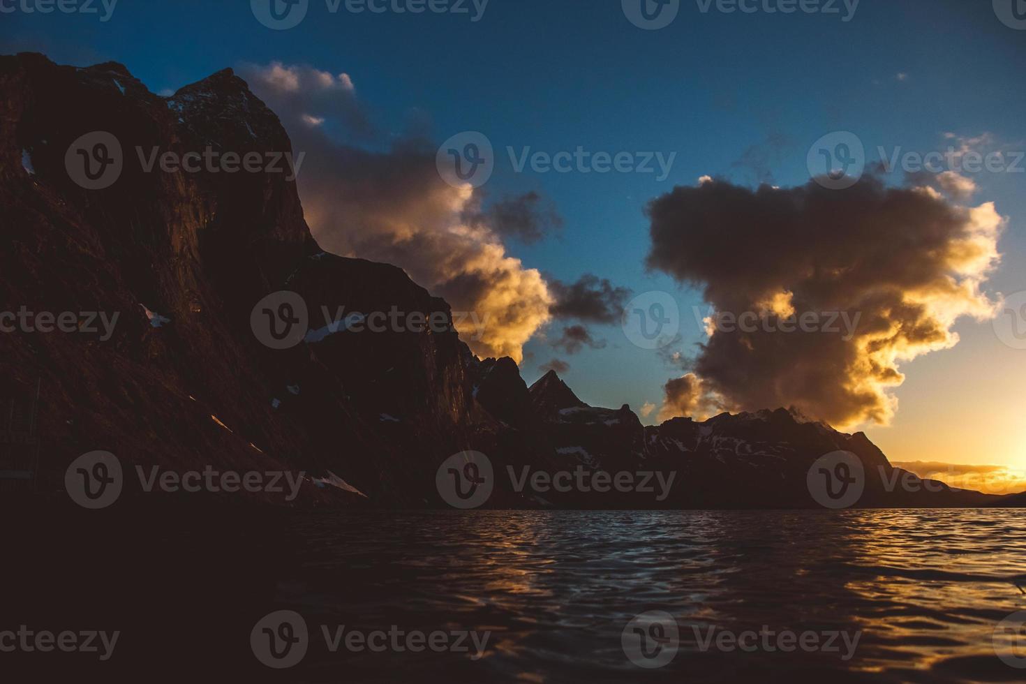 zonsondergang over de bergen aan zee. silhouet van de bergen foto