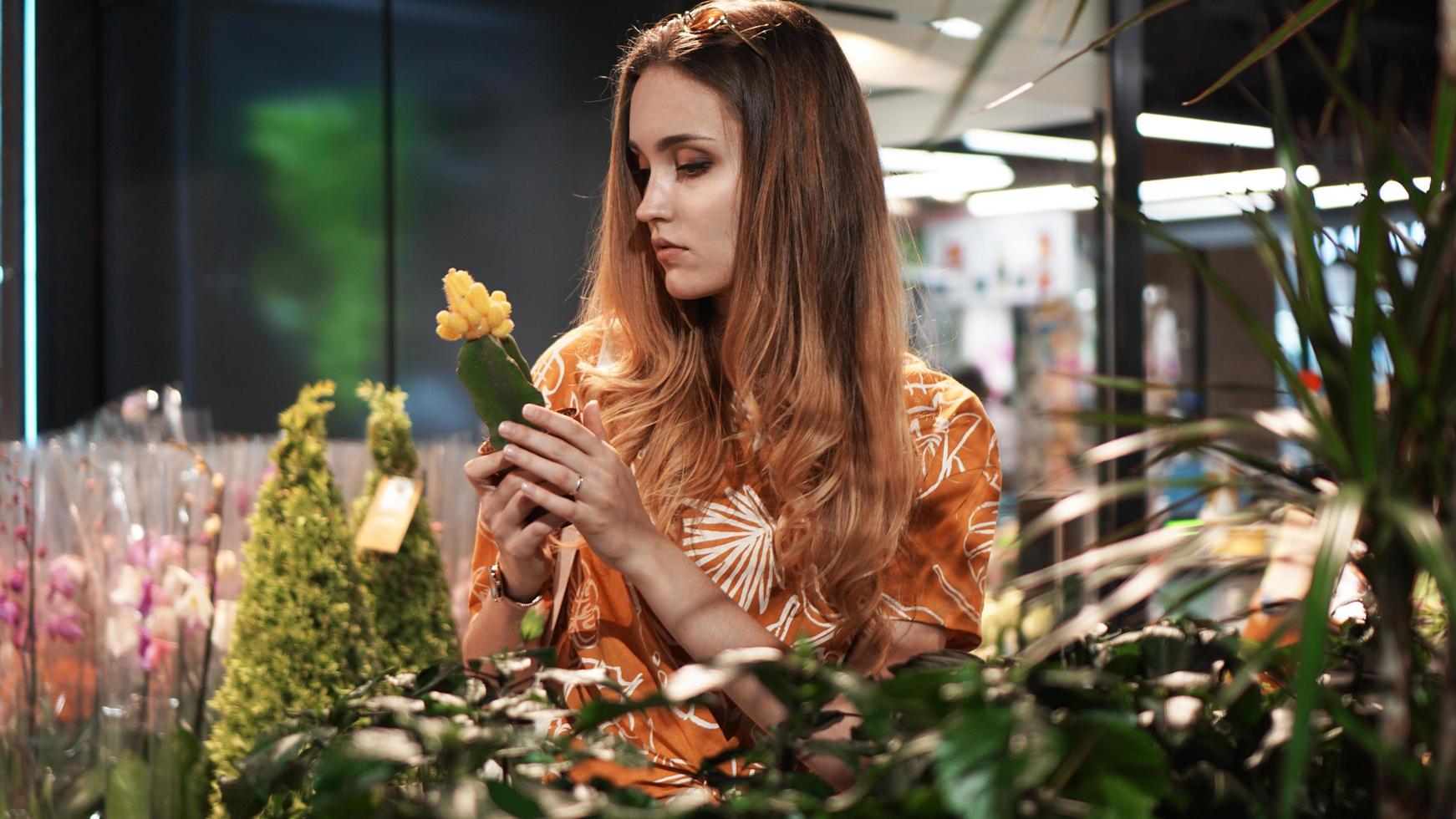 jonge vrouw die bloemen koopt in een tuincentrum foto