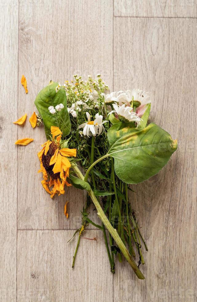 een boeket verdorde bloemen op de grond foto