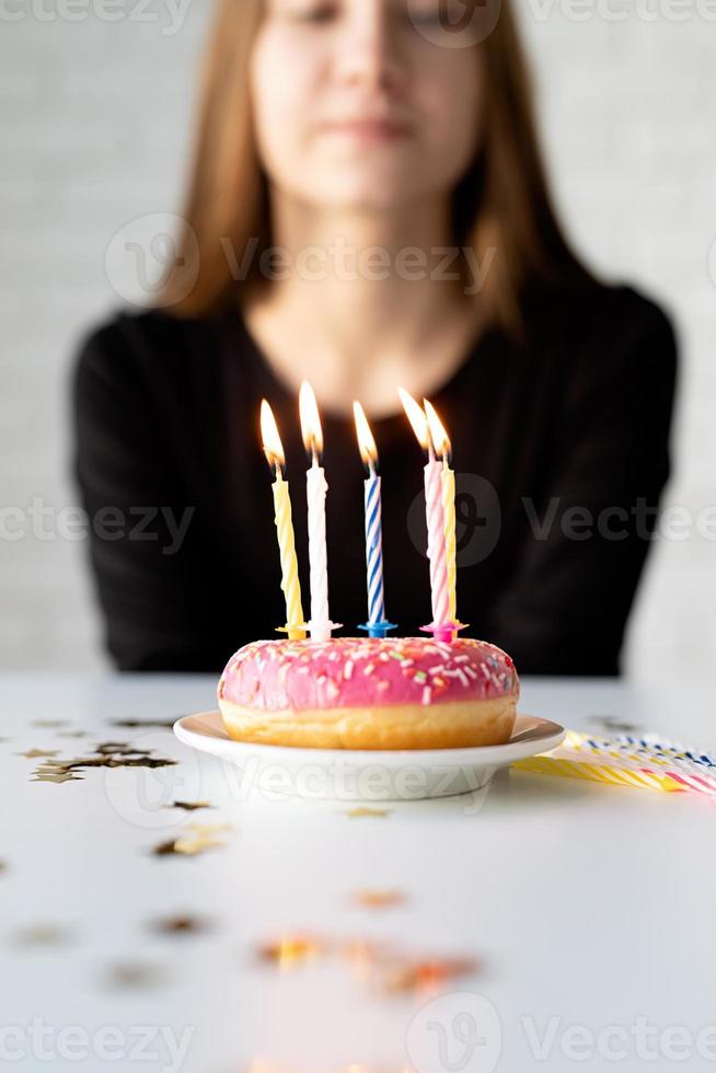 tiener feestvarken blaast kaarsen op de donut foto