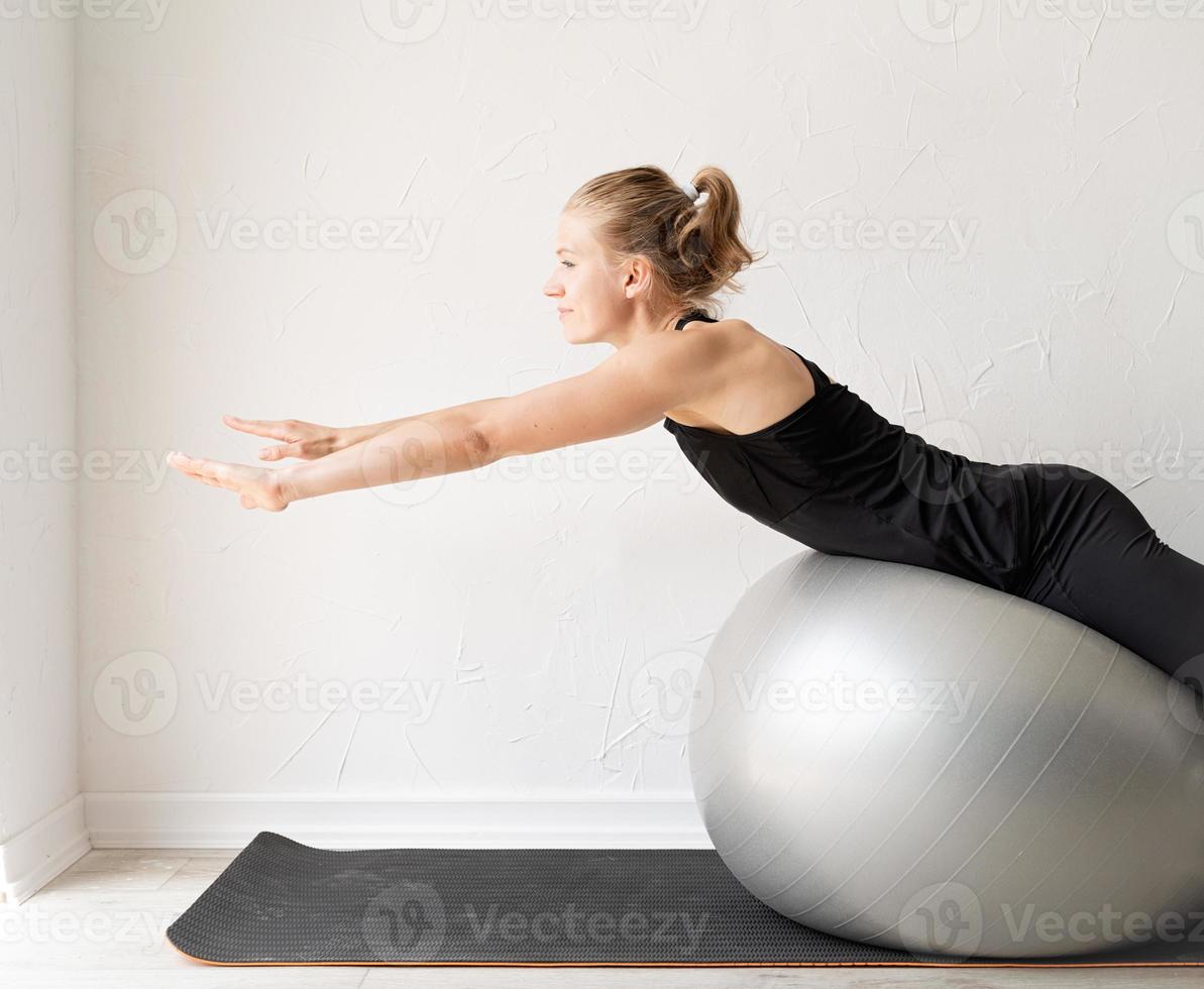 jonge sportieve vrouw zittend op de fitnessbal foto