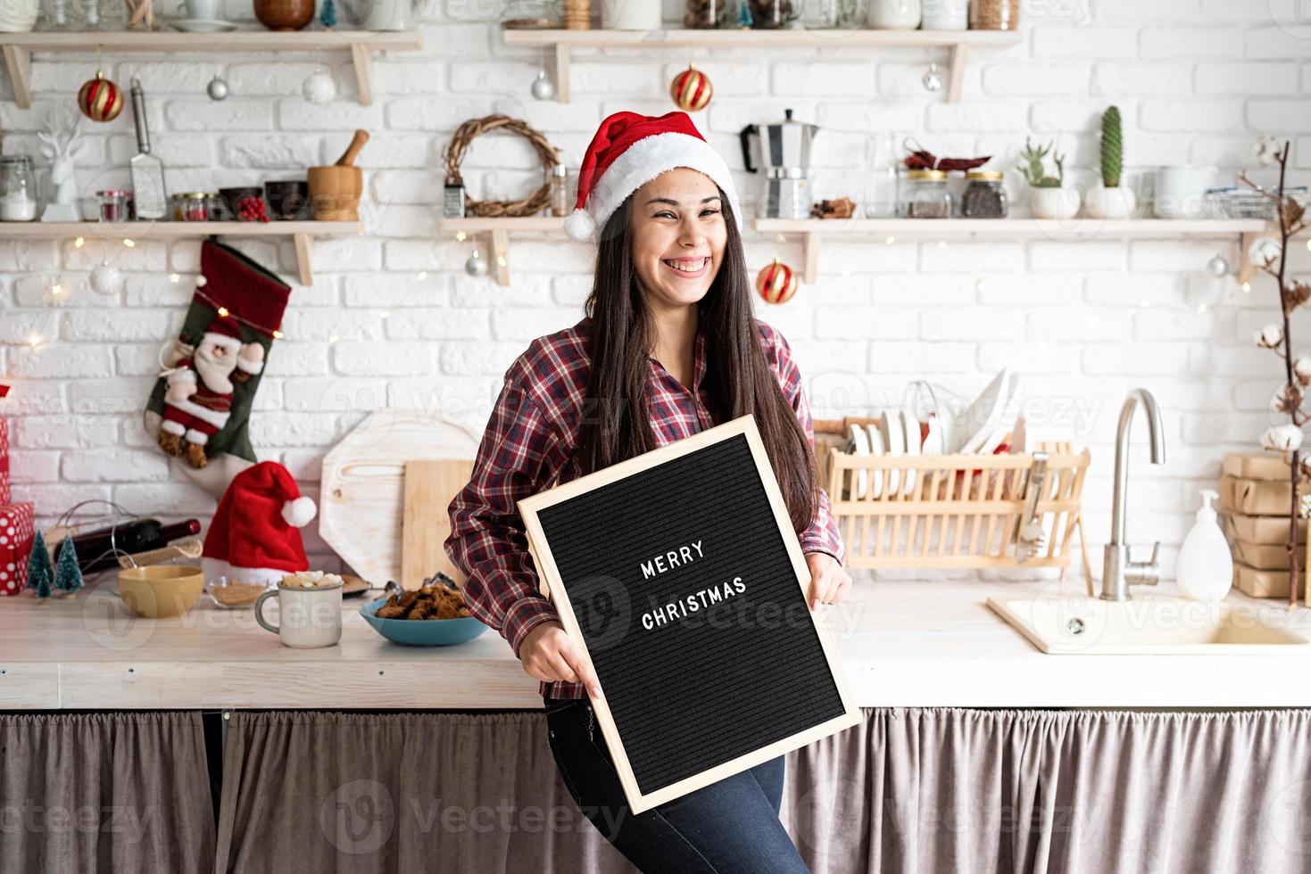 portret van een vrouw in kerstmuts met zwarte letterbord foto