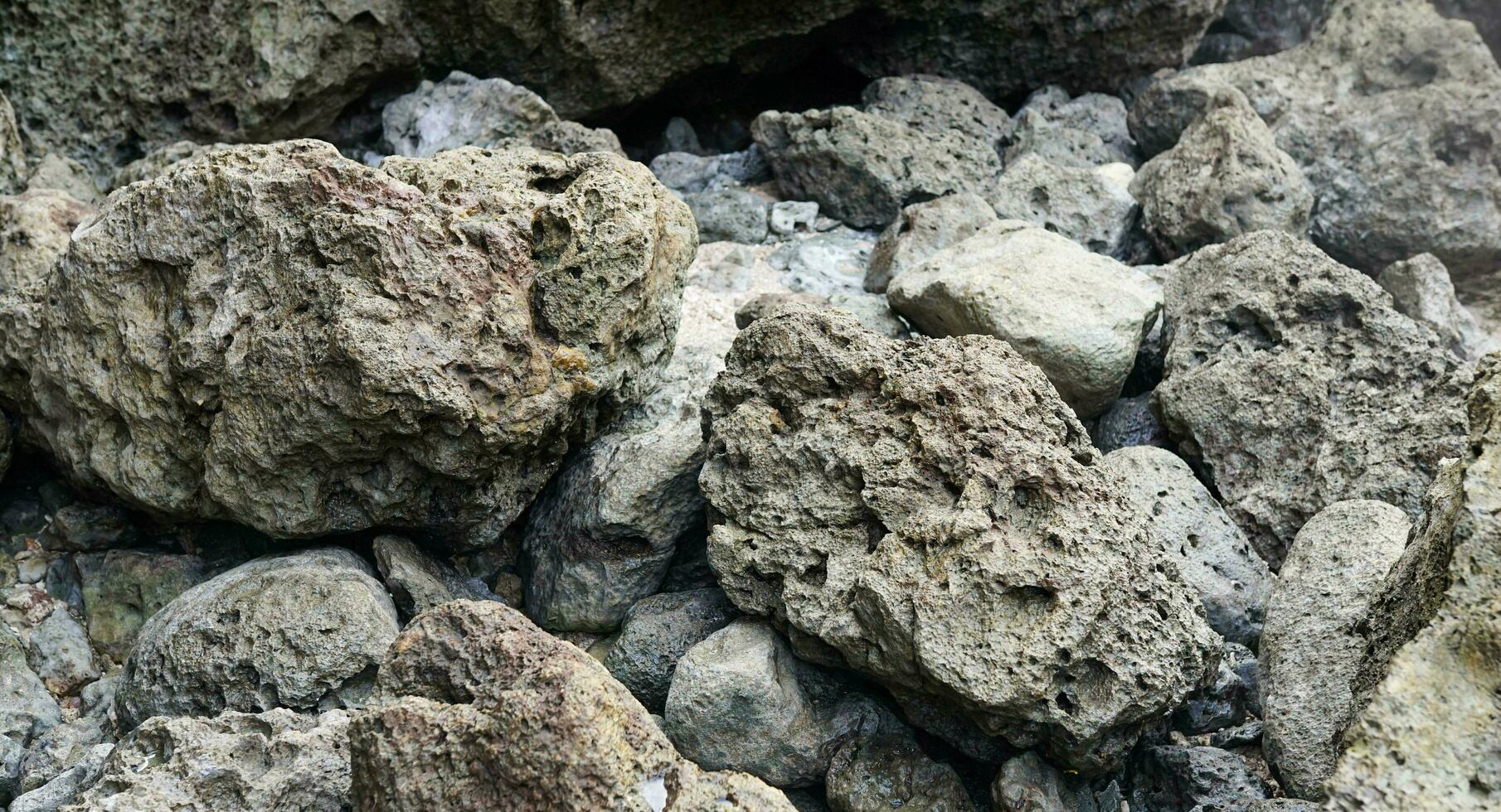 rots fragmenten van vulkaan, koraal rotsen Aan strand foto