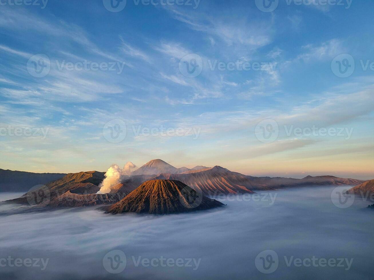 zonsopkomst visie van penanjakan 2 of seruni punt hieronder shows de mist nog steeds aan het bedekken de zee van zand en de voorkant visie van monteren batok met monteren bromo achter het nog steeds emitting vulkanisch rook. foto