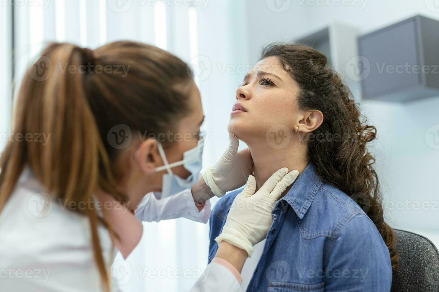 geneesmiddel, gezondheidszorg en medisch tentamen concept - dokter of verpleegster controle patiënten amandelen Bij ziekenhuis. endocrinoloog onderzoeken keel van jong vrouw in kliniek foto