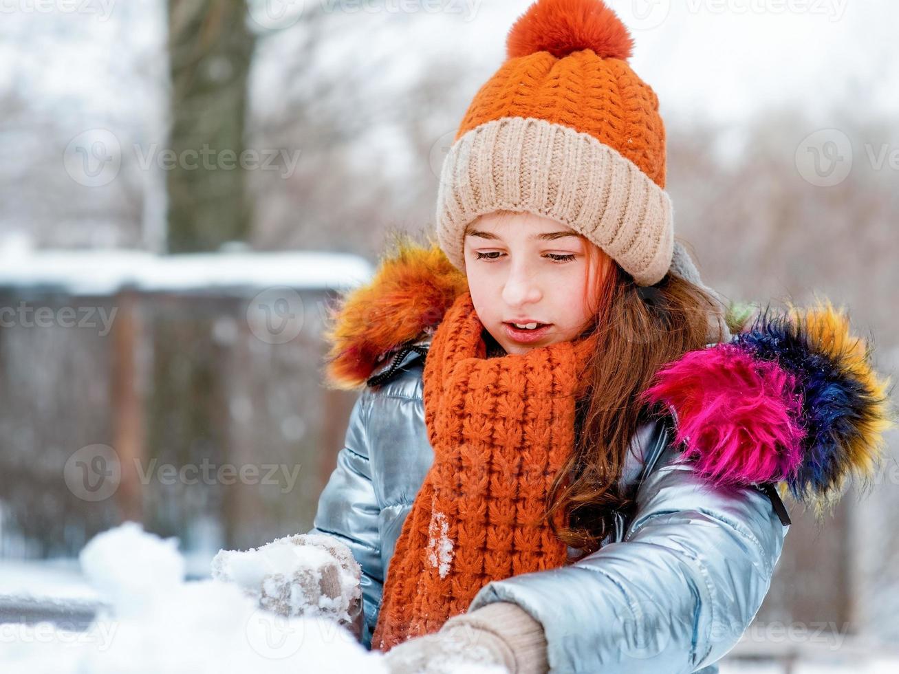 winter portret van jong meisje. tienermeisje in een hoed bij sneeuwweer. foto