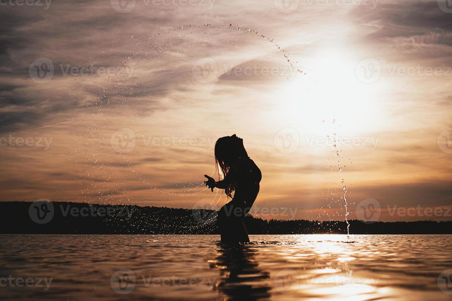 schoonheid model meisje opspattend water met haar haar. vrouw in het water. foto