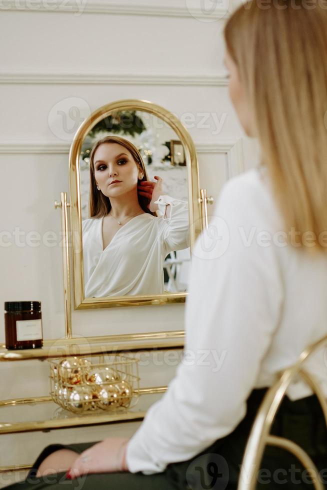 mooie vrouw in haar kamer bij haar kaptafel foto