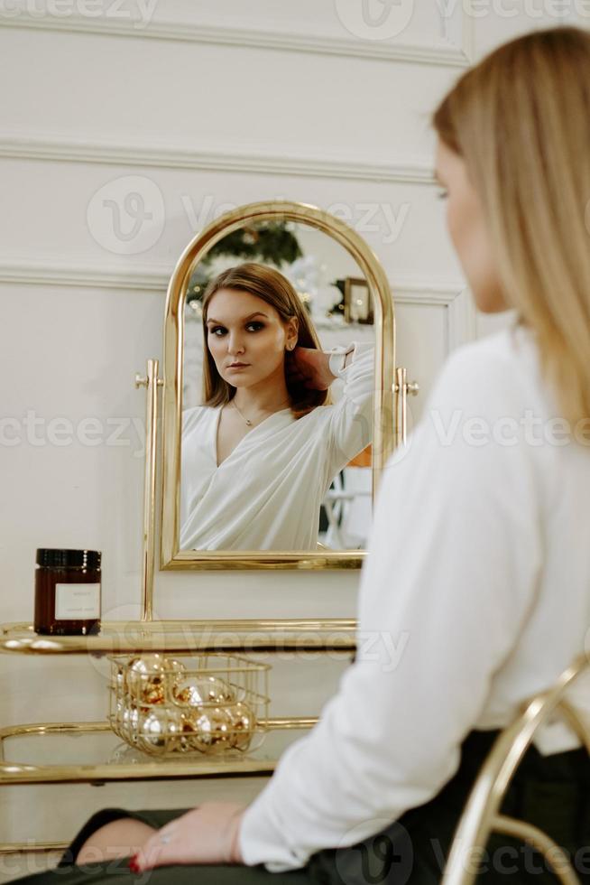 mooie vrouw in haar kamer bij haar kaptafel foto