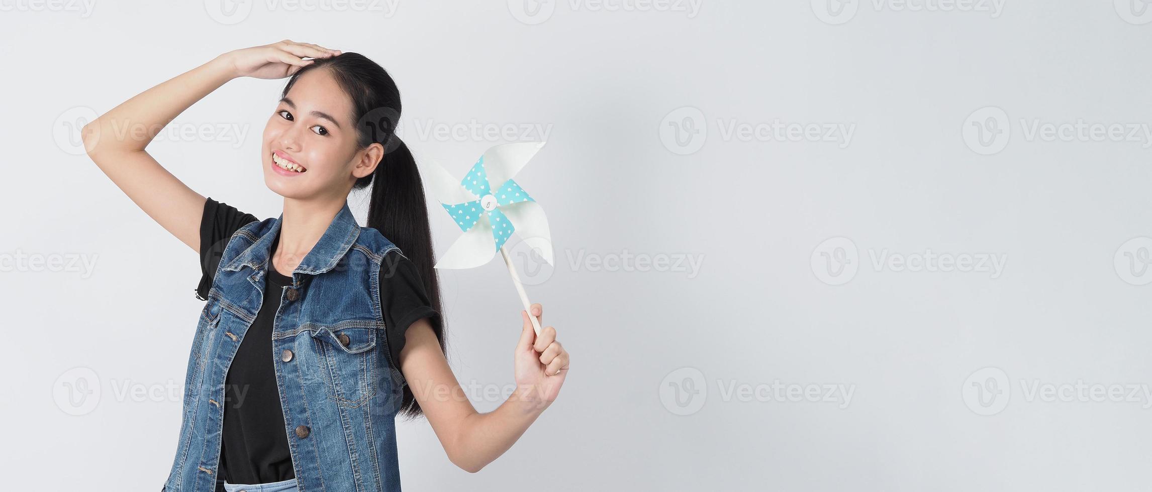 tiener vrouw en papier windmolen speelgoed. tiener met windwielstok foto