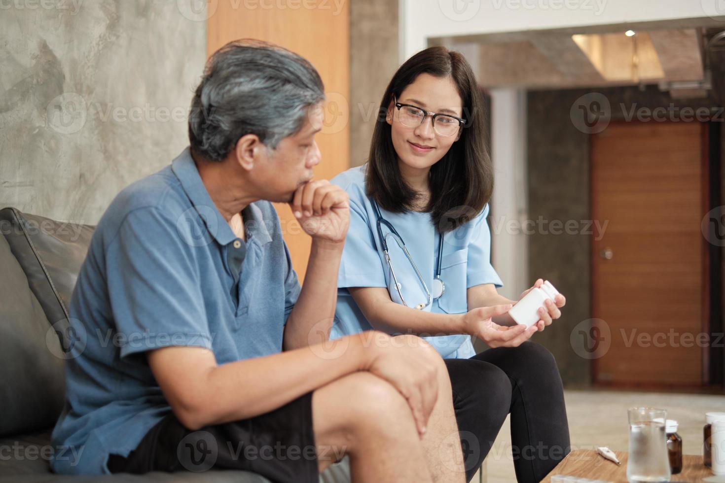 thuiszorg, vrouwelijke arts helpt mannelijke patiënt om medicijnen te nemen foto