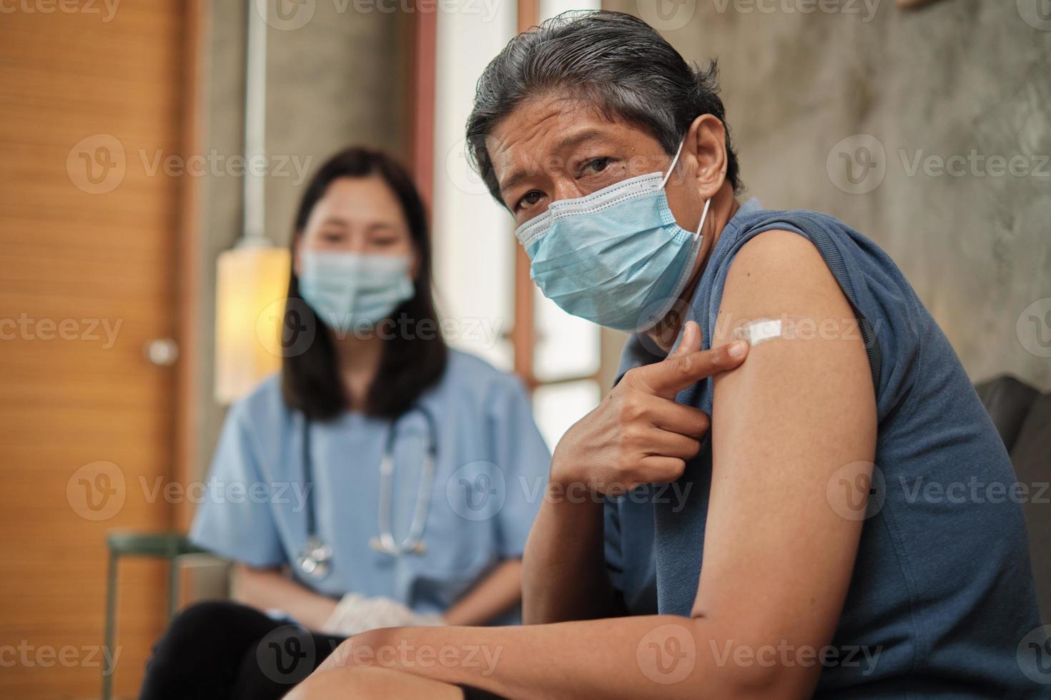 oudere patiënt wijst vinger naar arm na vaccinatie. foto