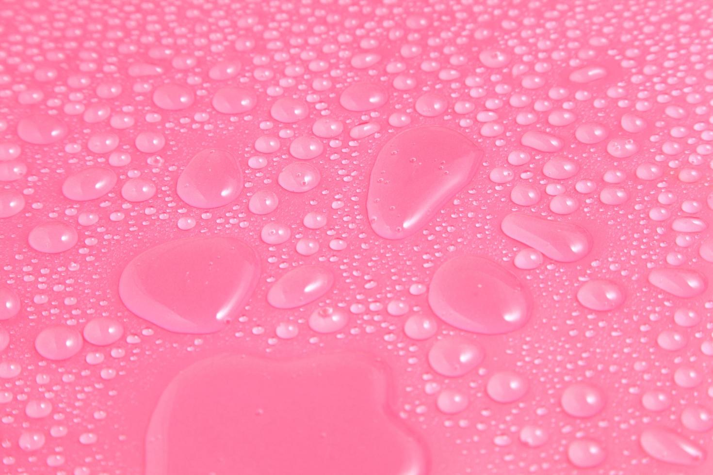 close-up waterdruppels op roze achtergrond foto