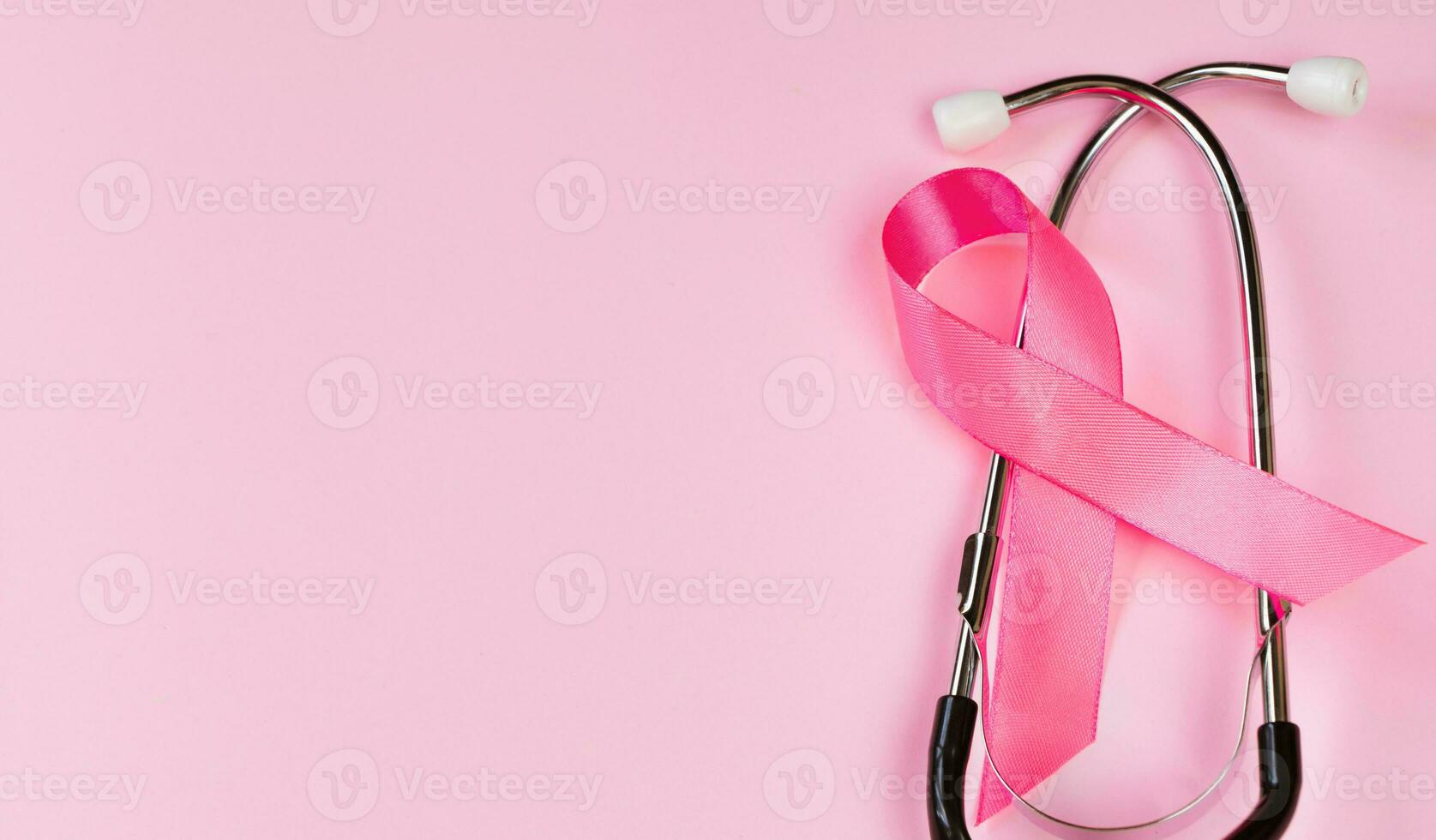 borst kanker bewustzijn maand. roze lint en stethoscoop Aan gekleurde achtergrond. vrouwen Gezondheid zorg concept. symbool van strijd tegen oncologie. foto