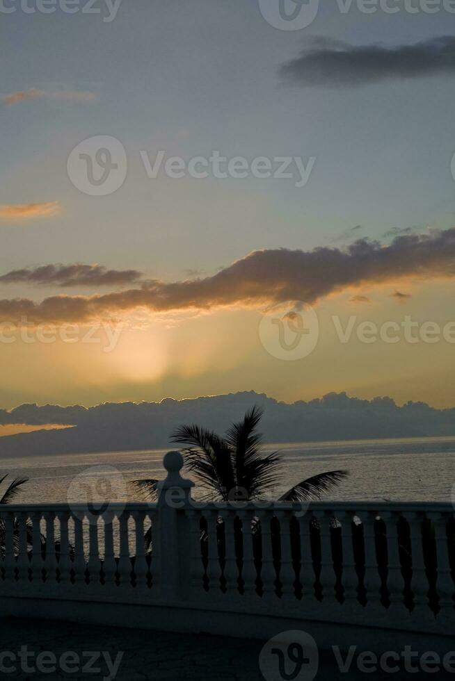 pittoreske oceaan landschap met de instelling zon in een tropisch land gedurende zomer vakantie met palm foto