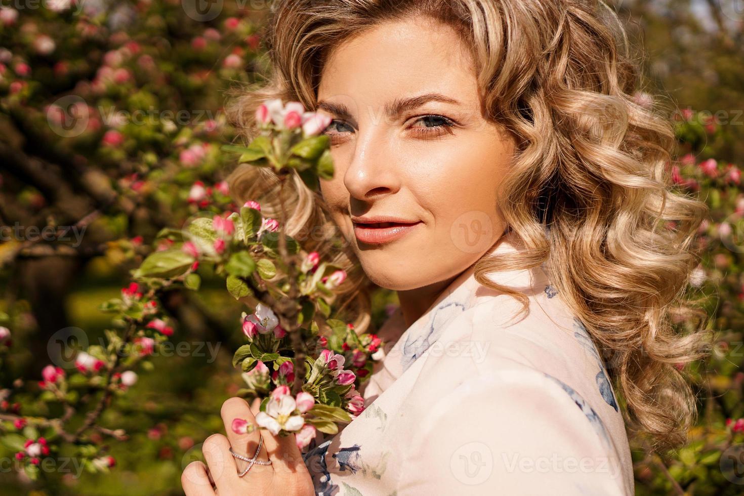 romantische jonge vrouw in de lentetuin onder appelbloesem. foto