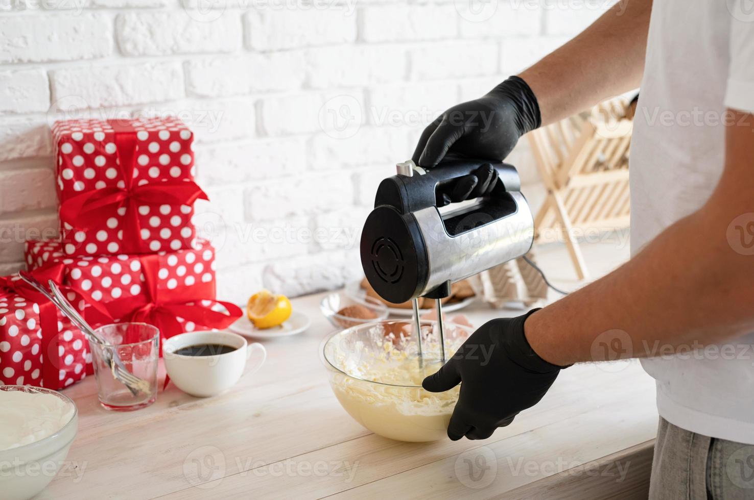 mannelijke handen die bisquick-deeg mengen met elektrische mixer in een keuken foto